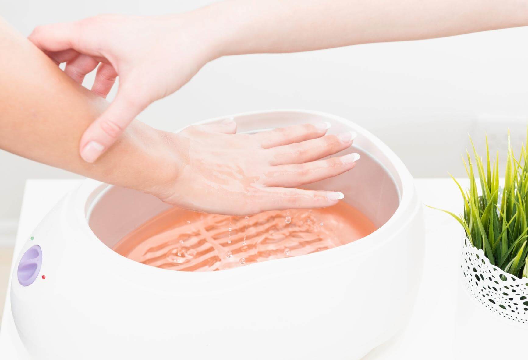 Hand hovering above a paraffin wax dip